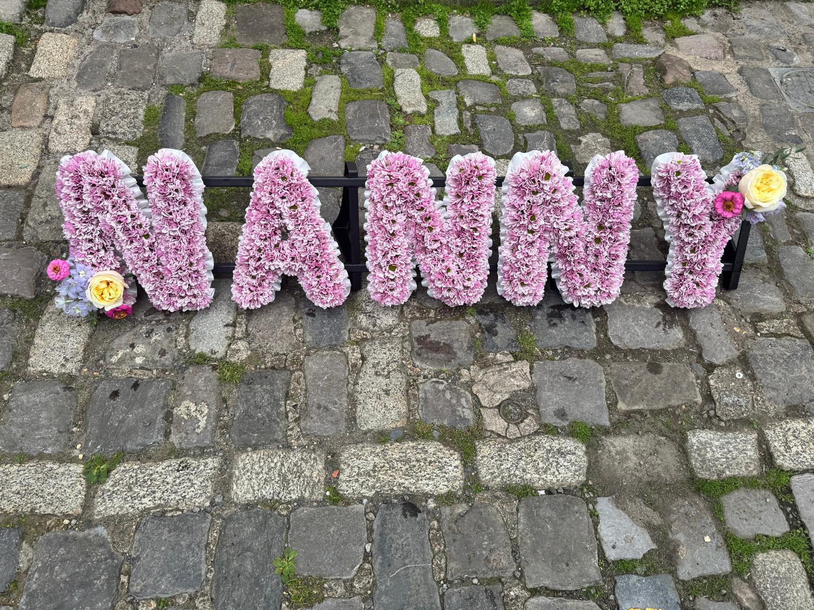 NANNY lettered funeral tribute in pink chrysanthemum by Bristol Floral Design